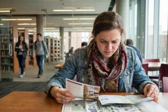 Jeune femme examine des cartes dans une salle d'universite