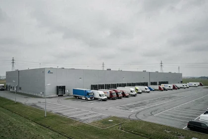 Vue extérieure du site hub logistique d'Harnes dans le Pas-de-Calais, avec quais de chargement et camions de livraison